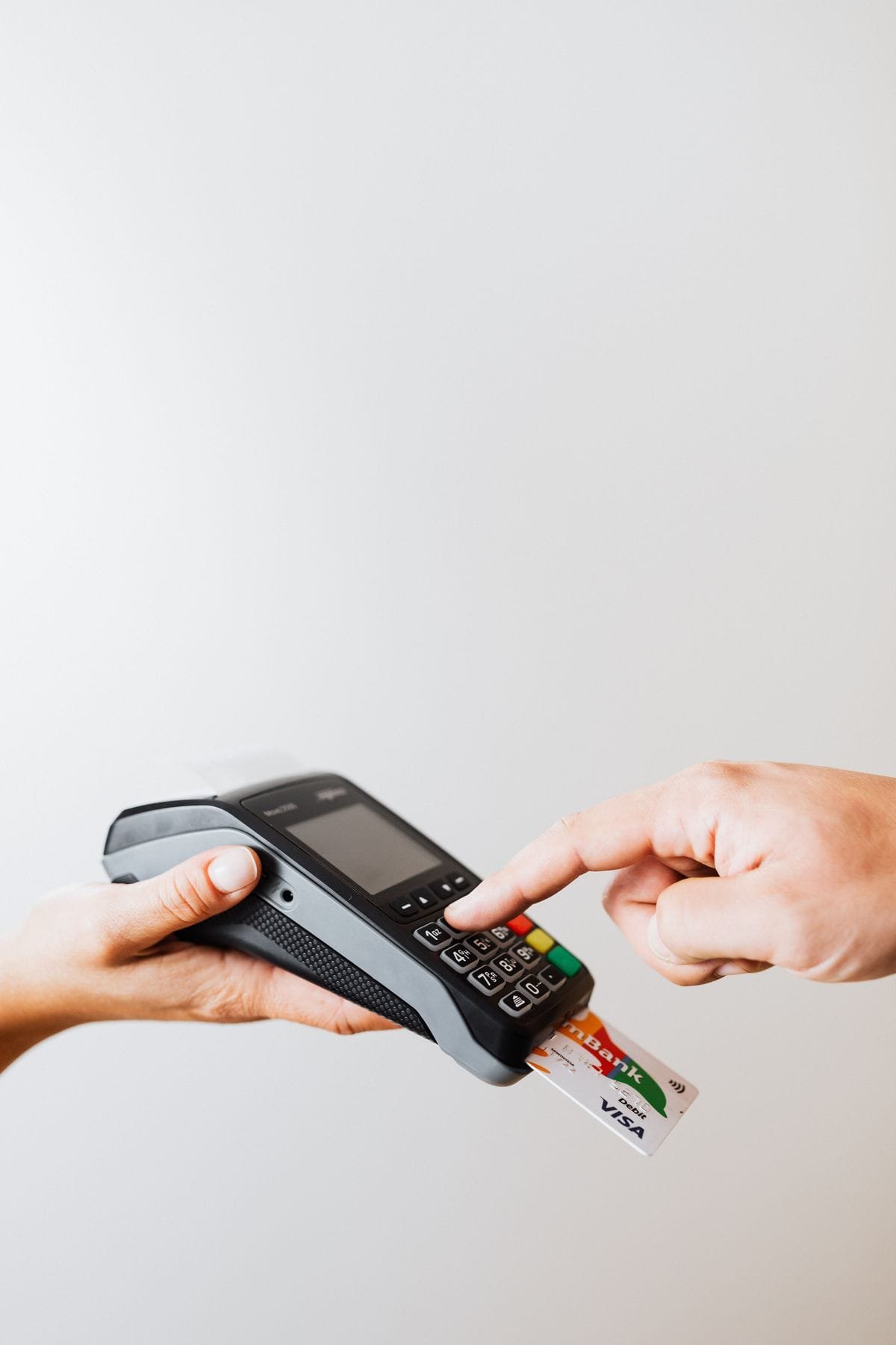 A customer paying by card on a POS terminal